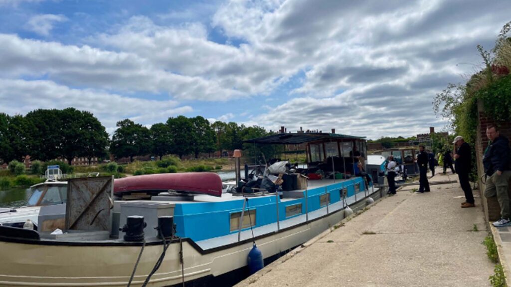 Enforcement officers inspect boats moored on the River Thames during an operation targeting unauthorised moorings near Hurst Park.